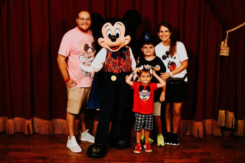 family posing with Mickey Mouse in Disney World 