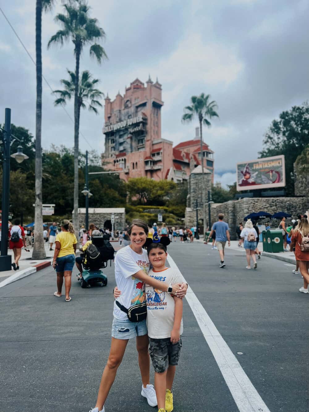 mother and son posing in front of Hollywood Tower Hotel in Hollywood Studios at Disney World