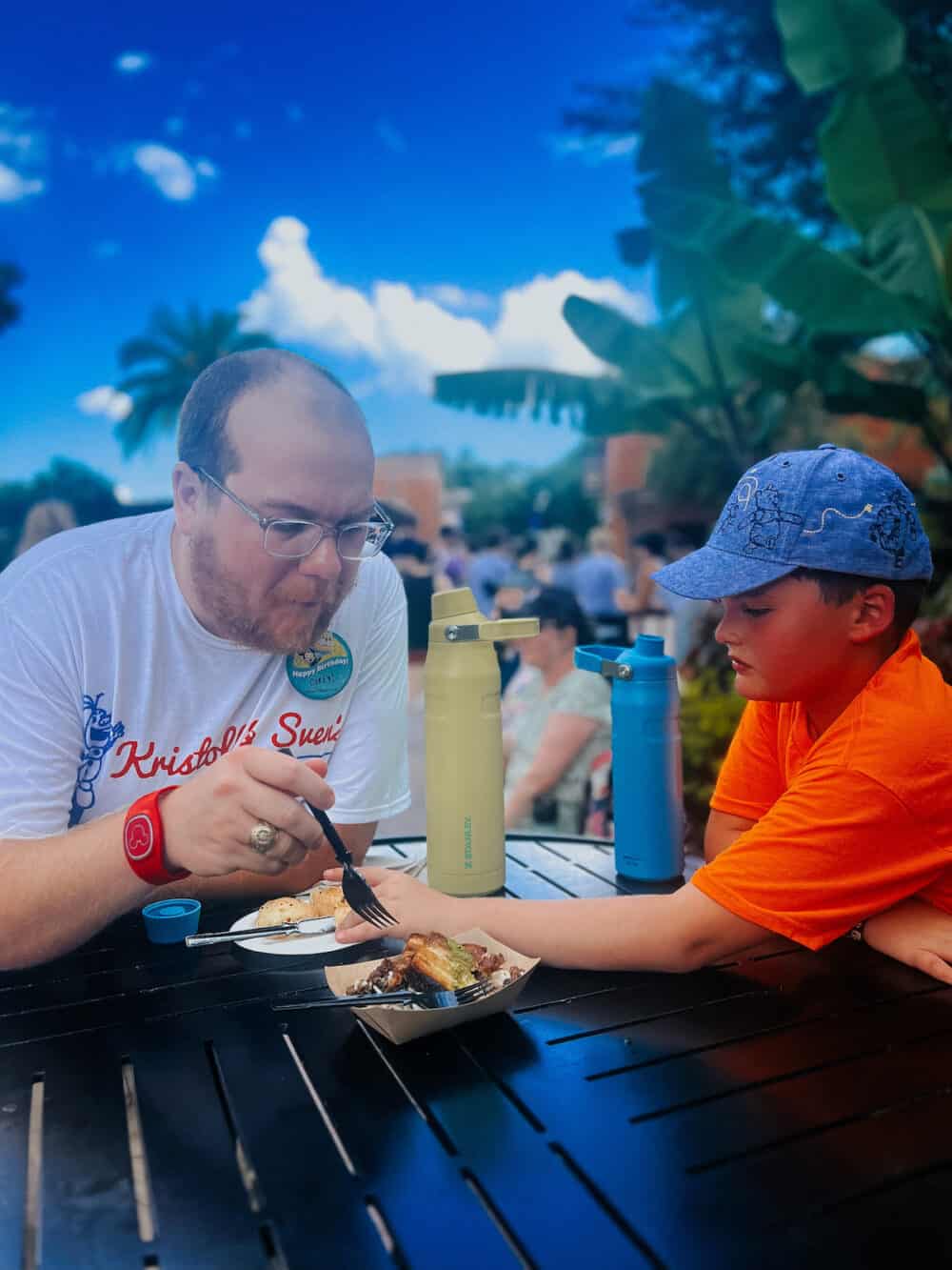 father and son having a snack in Epcot at Disney World 
