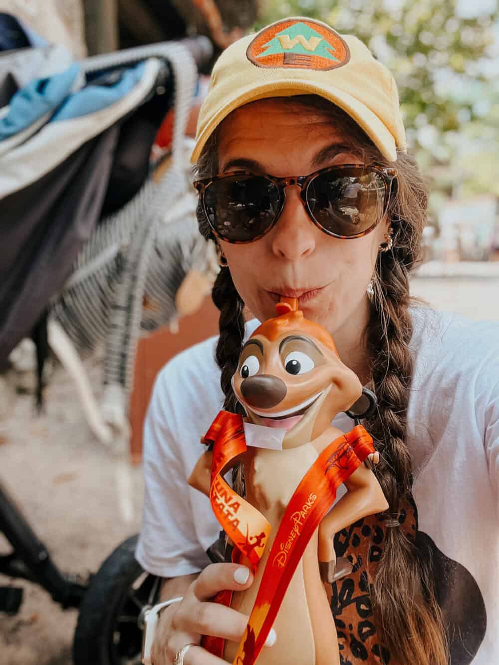 woman drinking out of a Timon sipper at Animal Kingdom in Disney World 