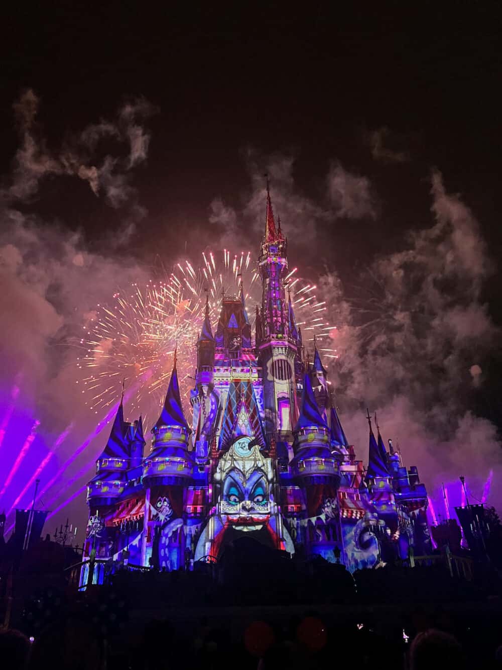 Cinderella castle in Disney World lit up during Halloween party fireworks 