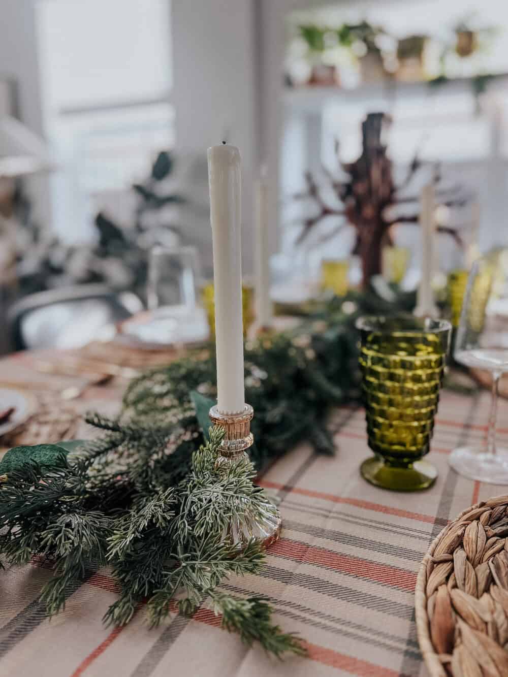 close up of thanksgiving table with greenery and candles 