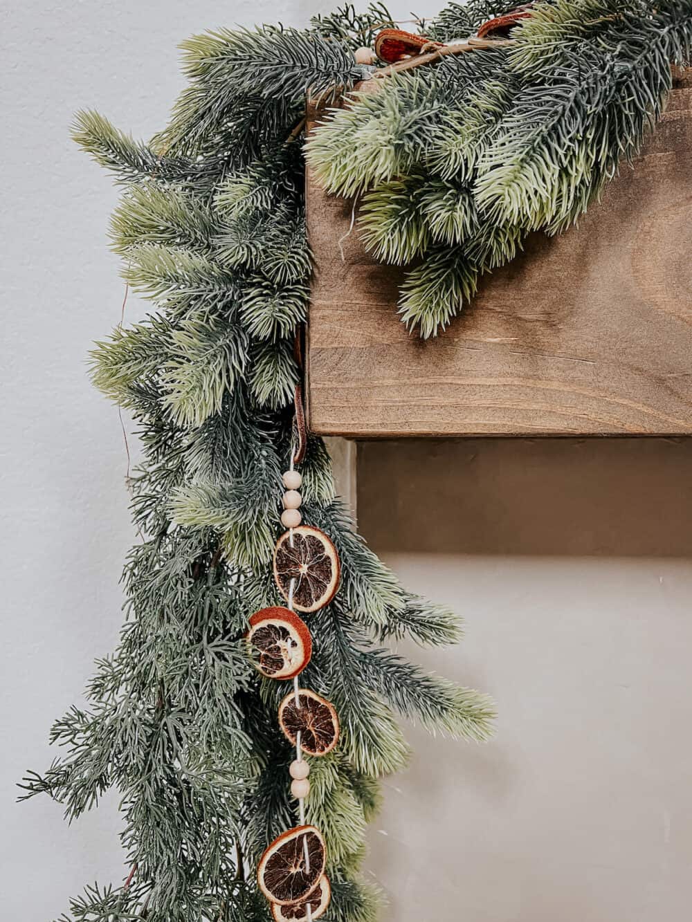 dried orange slice garland mixed into a green garland on a mantel