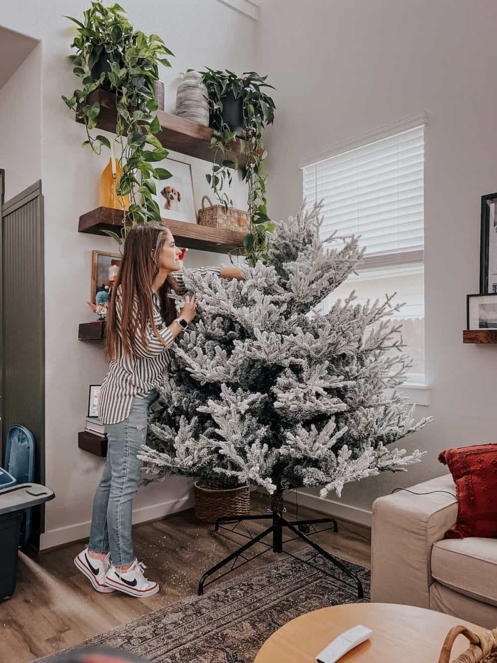 Woman assembling a flocked Christmas tree 