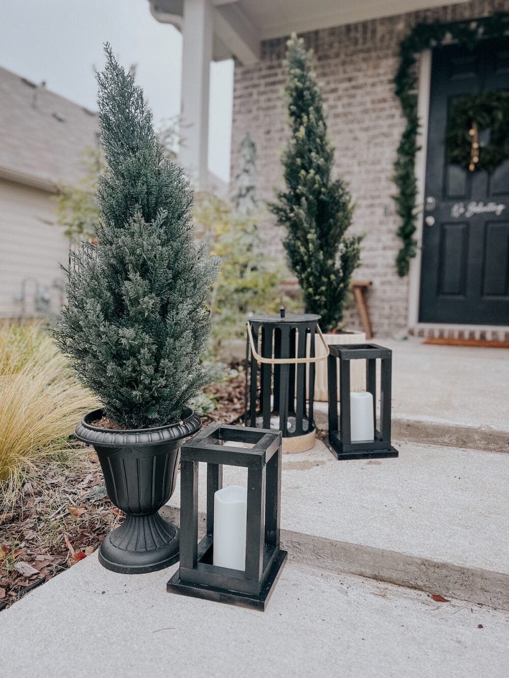 Faux evergreen trees on a front porch 