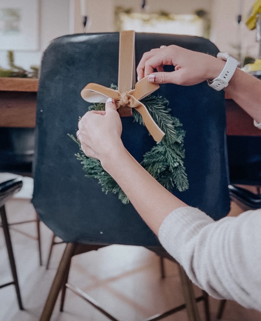 woman adjusting a ribbon on the back of a chair 