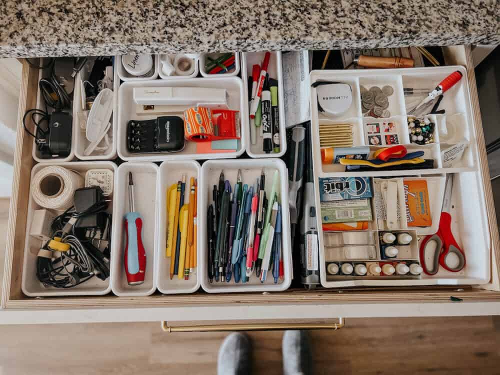 A fully organized junk drawer with multiple organizers in place 