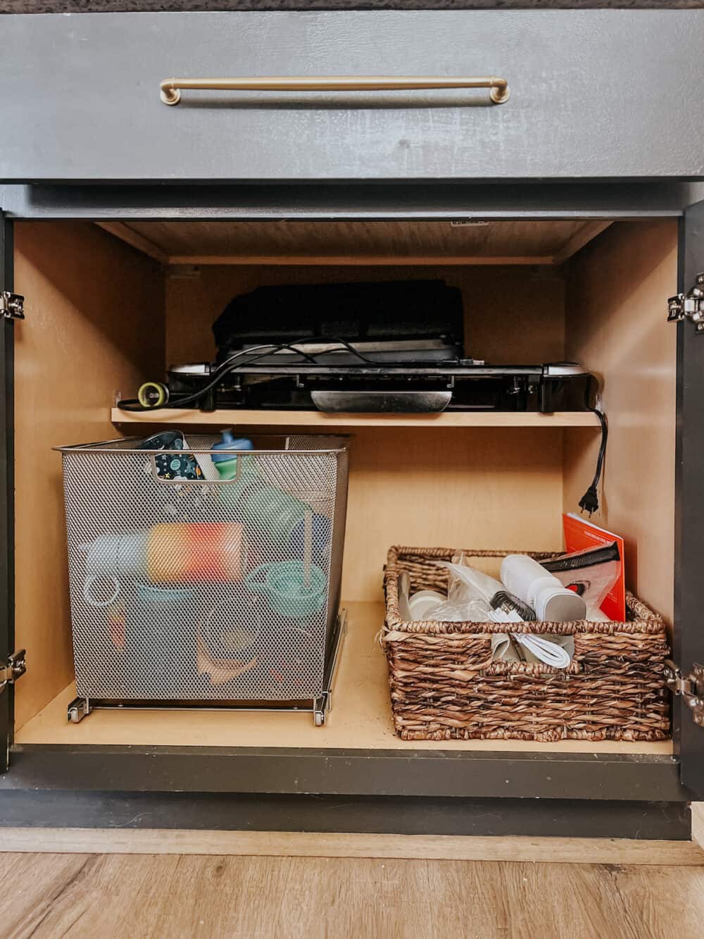 An organized cabinet with a mesh pull out cabinet drawer