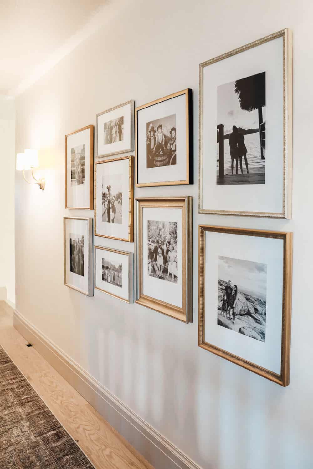 a silver and gold black and white gallery wall of family pictures 