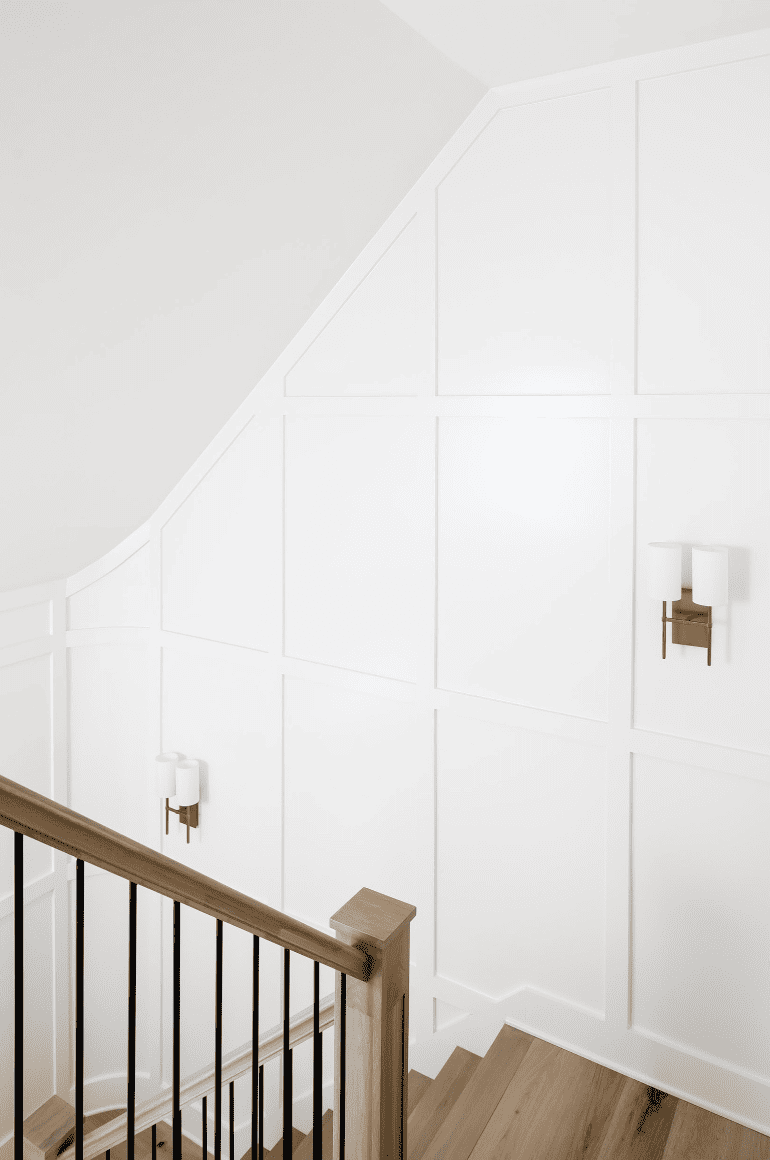a white staircase wall with moulding