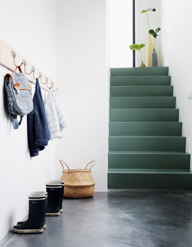 an entryway with a staircase painted green