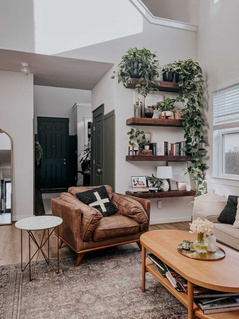 living room with a cozy leather chair and DIY floating shelves on the wall 