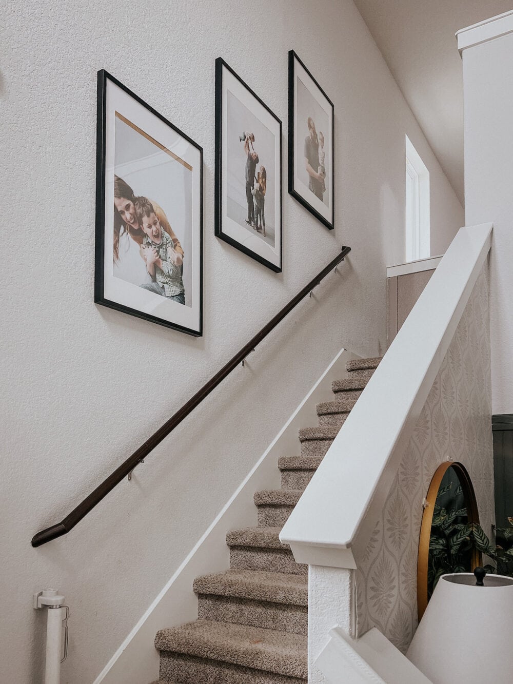 a staircase with three large frames on the staircase wall