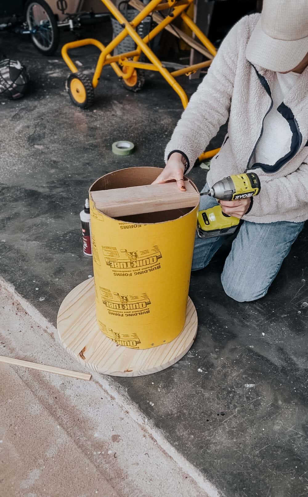 Woman using a drill to add supports into a side table 