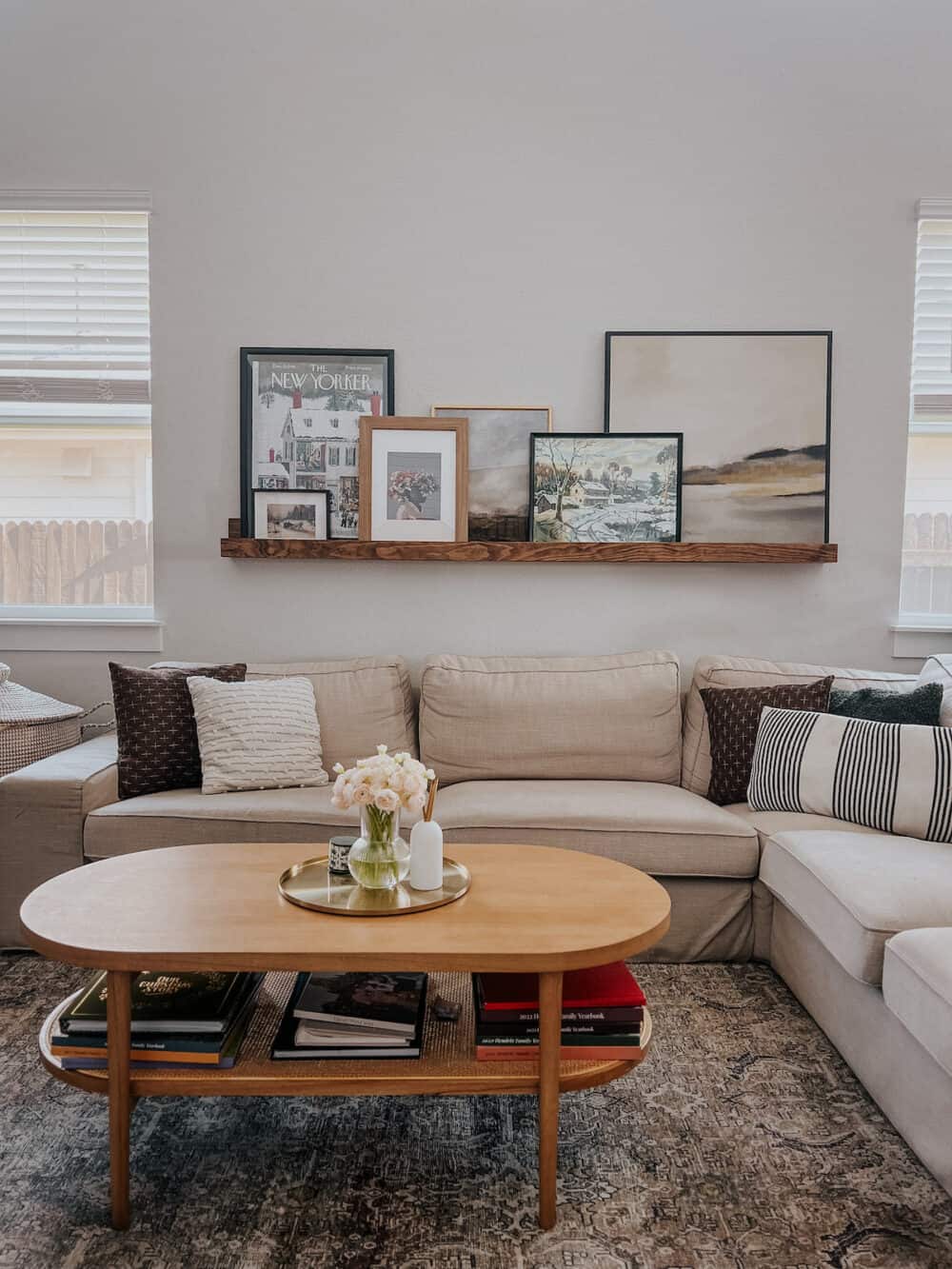 a living room with a cozy neutral vibe and a large picture ledge on the wall, featuring throw pillows from Amazon