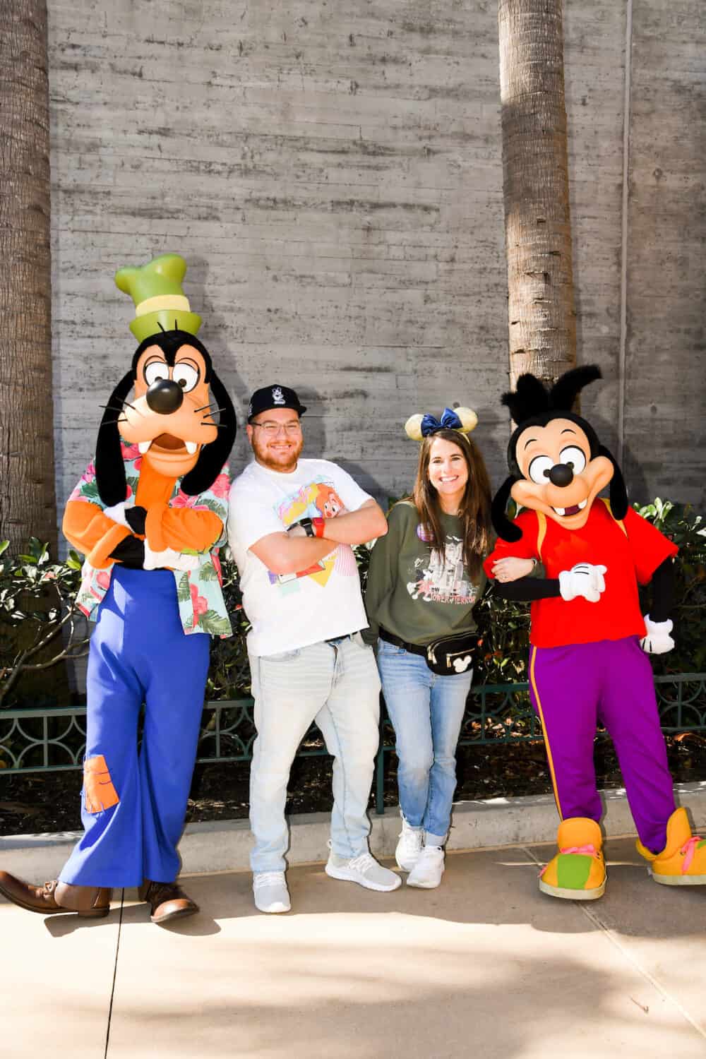 couple posing with Max and Goofy in Hollywood Studios at Disney World 