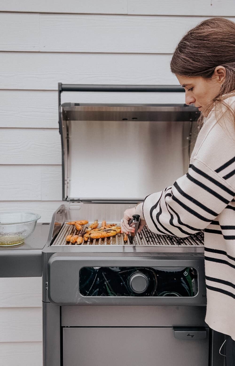 woman grilling on a Current Dual Zone Electric Grill