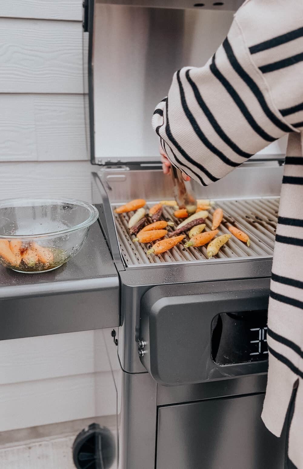 woman cooking carrots on an electric grill 