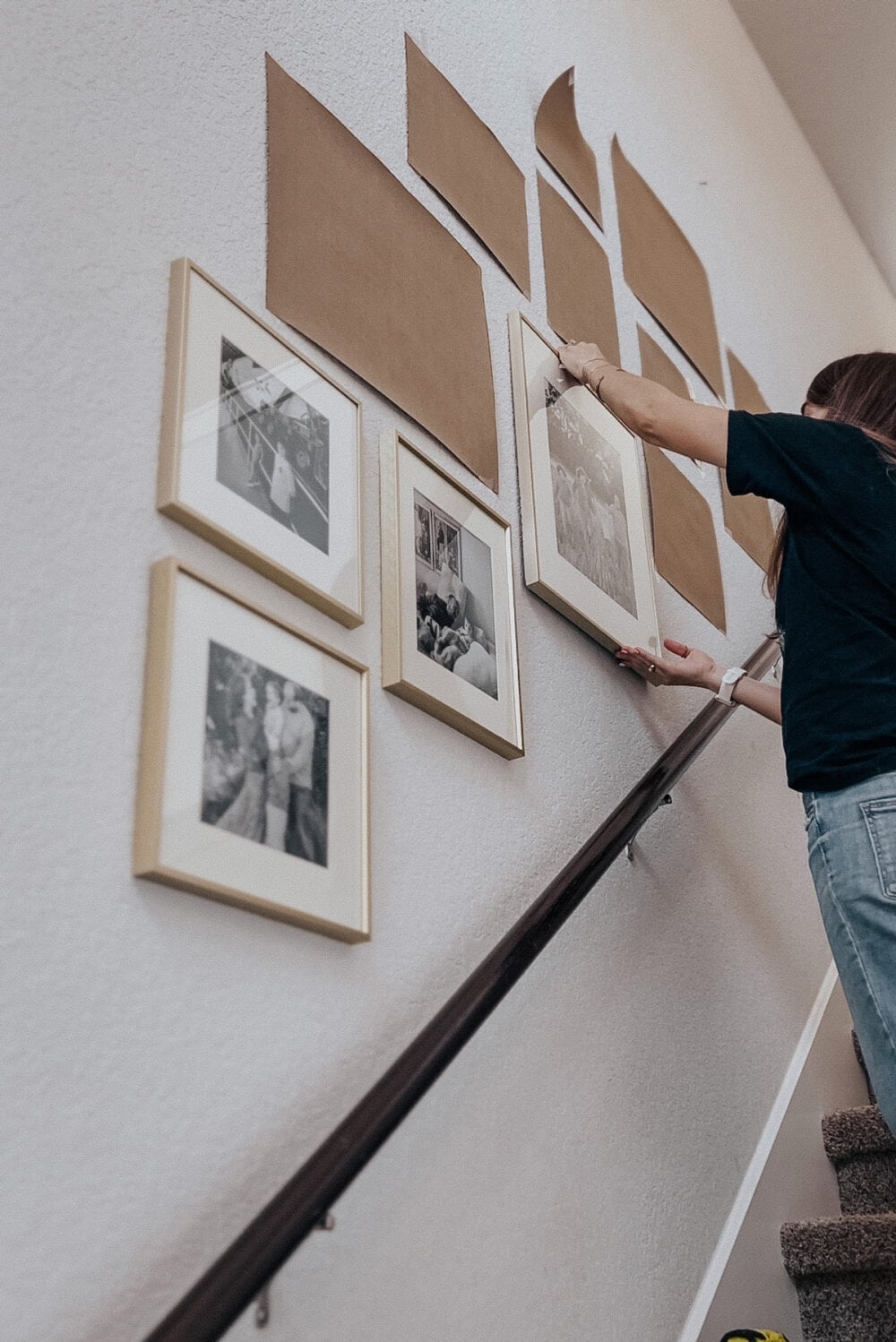 Woman hanging a frame in a gallery wall