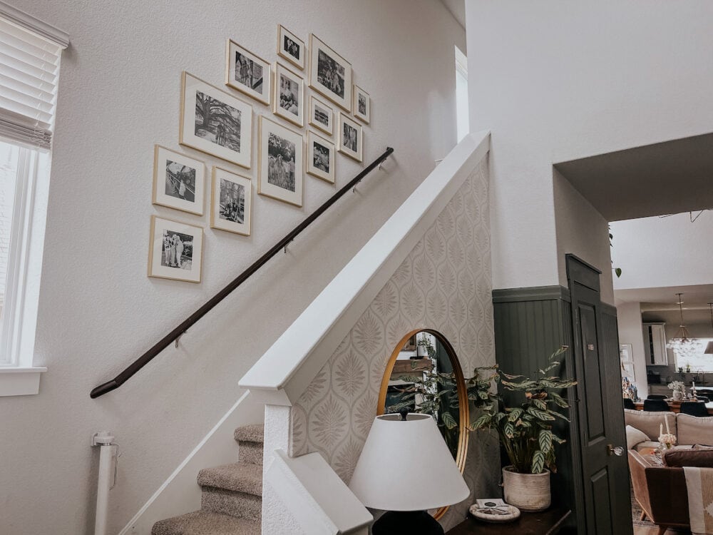 a home's entryway with a family photo gallery wall on the staircase