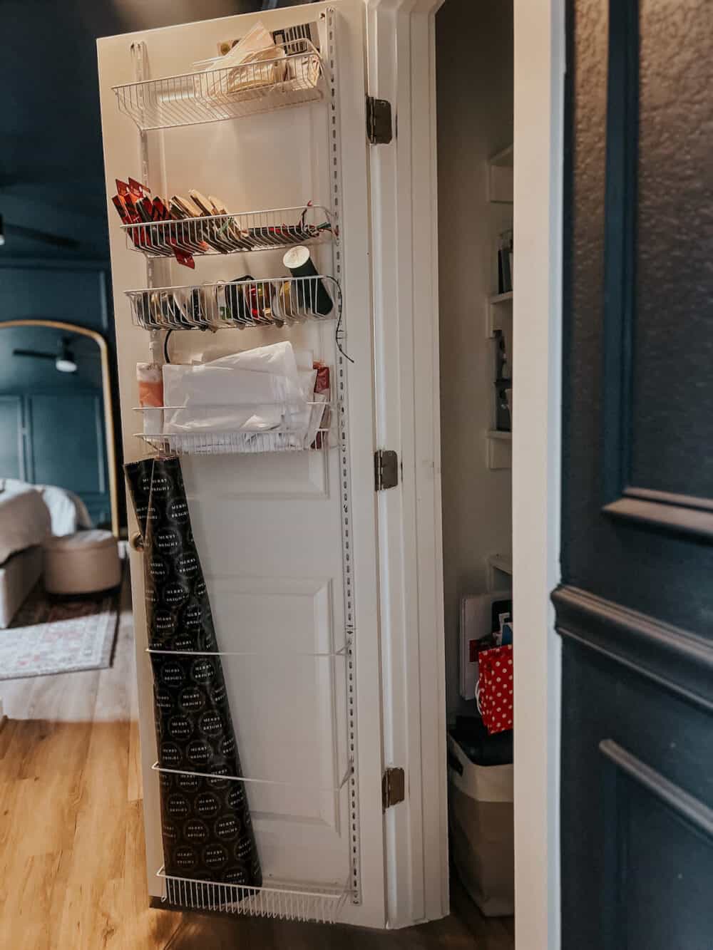 a door organizer on a linen closet holding wrapping paper