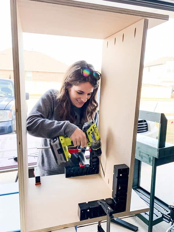 woman assembling a diy nightstand