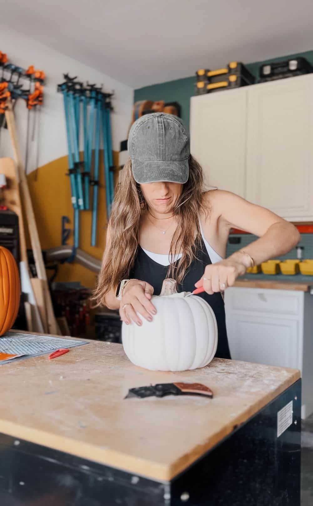woman carving a faux carvable pumpkin