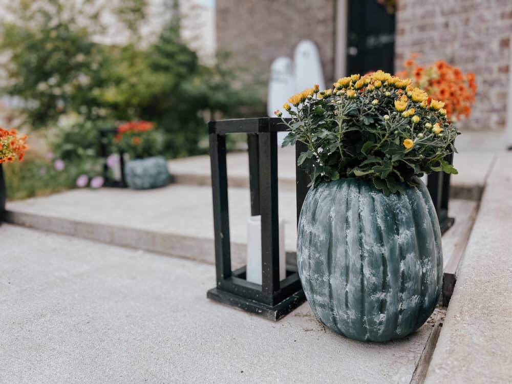 A DIY faux pumpkin planter on a front porch