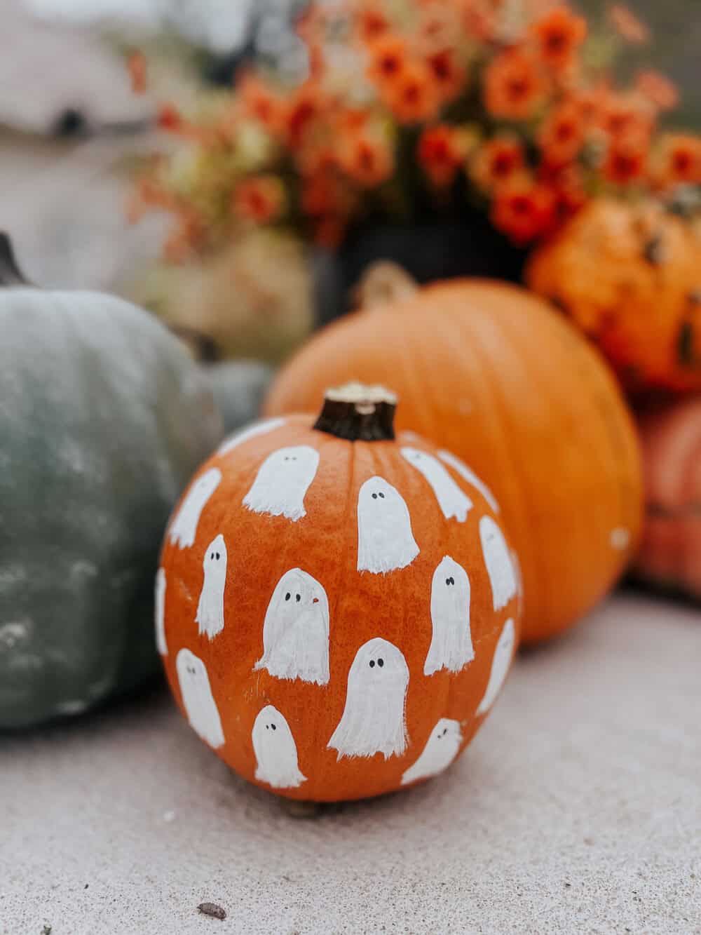 small pumpkin with ghosts painted on it 