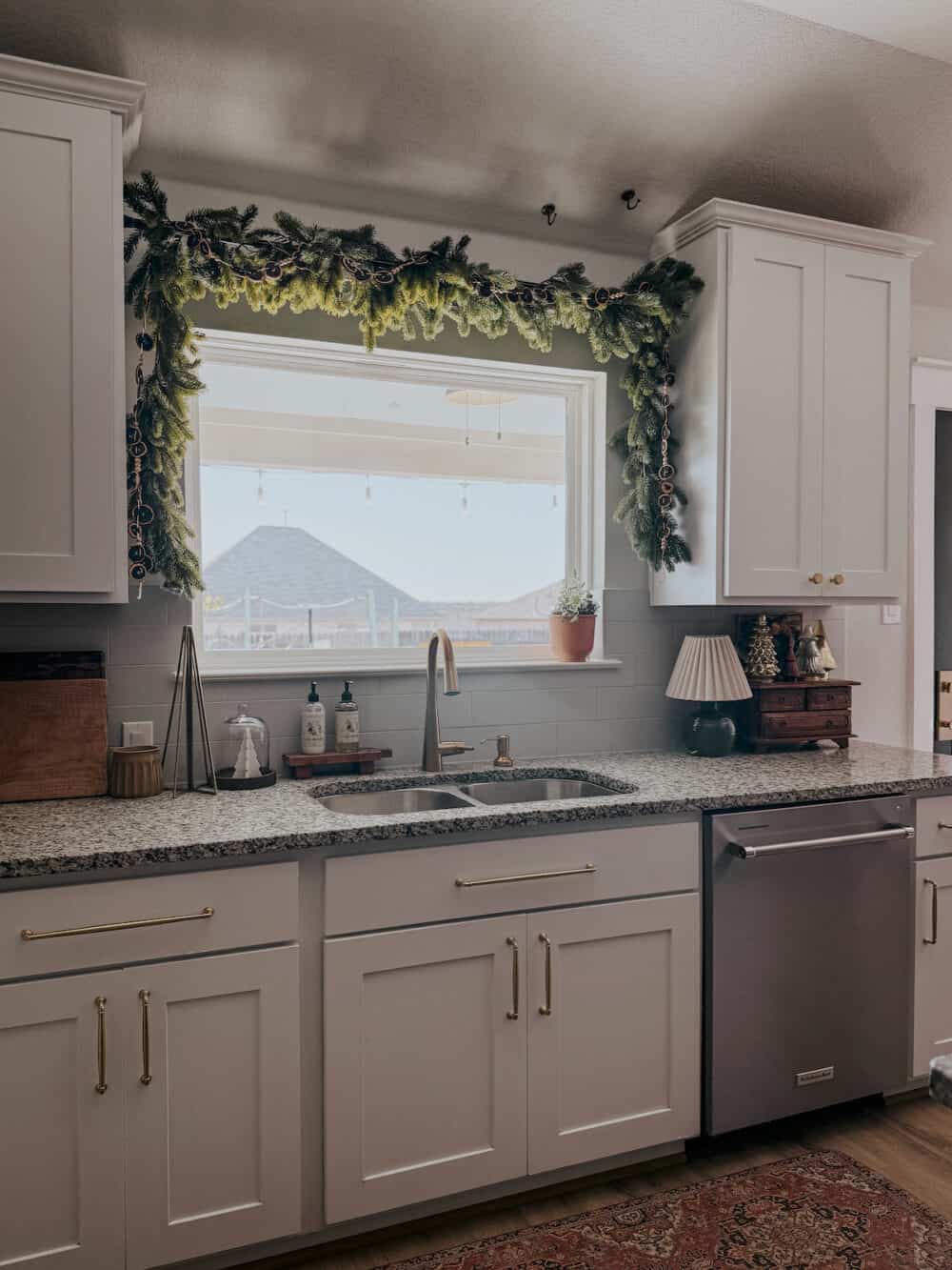 kitchen with a tension rod holding a garland hanging above the kitchen sink