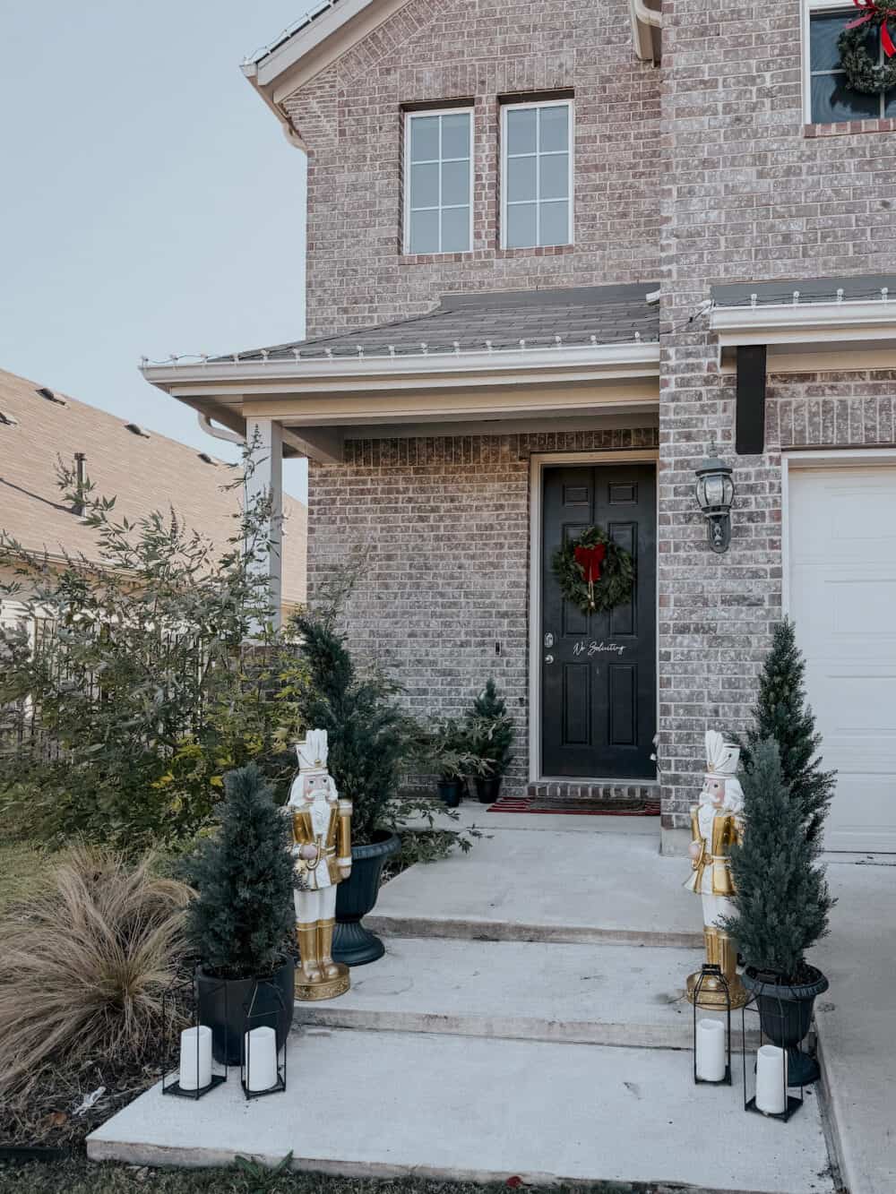 front porch with nutcrackers and trees decorated for Christmas