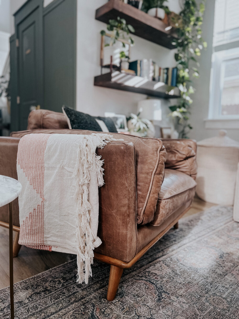 throw blanket styled over the arm of a leather chair
