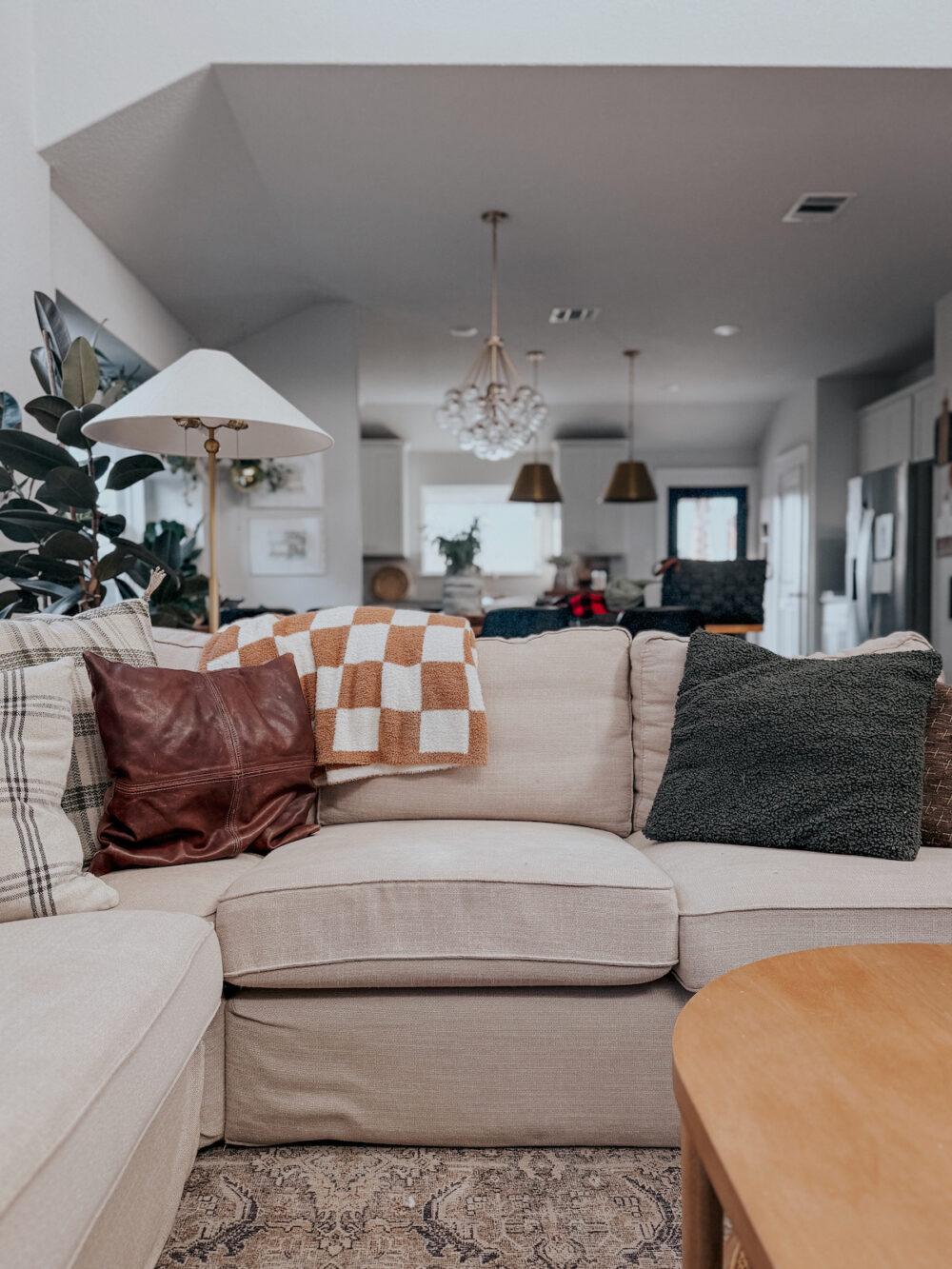 Living room sofa with a checkered blanket folded over it 