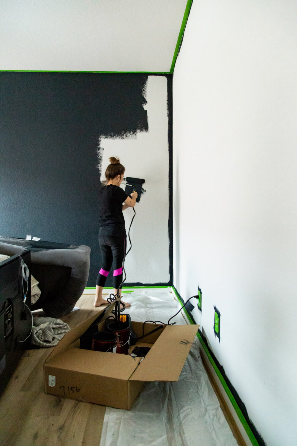 woman painting Behr Ink Black on a wall