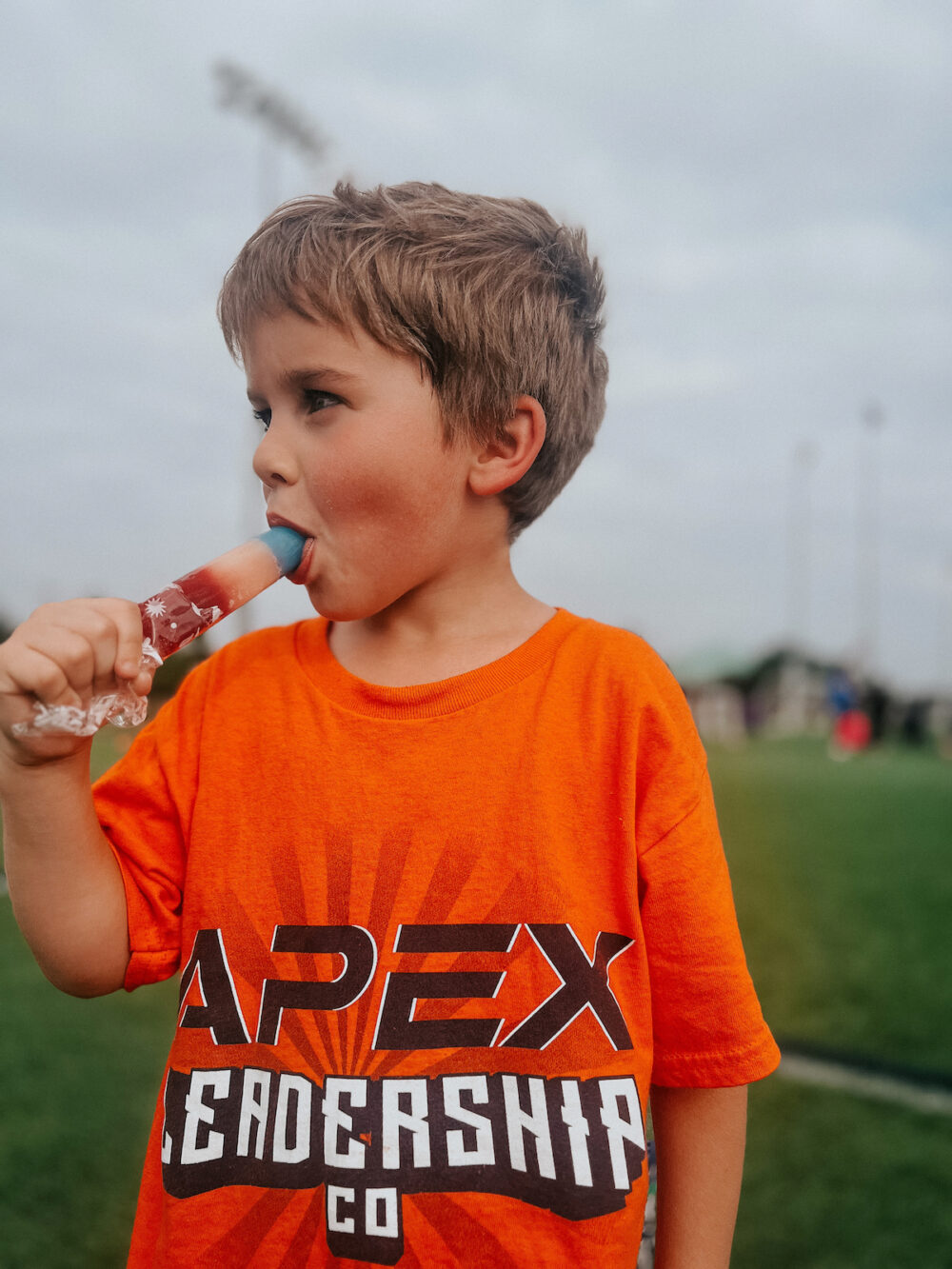 a young boy eating a popsicle