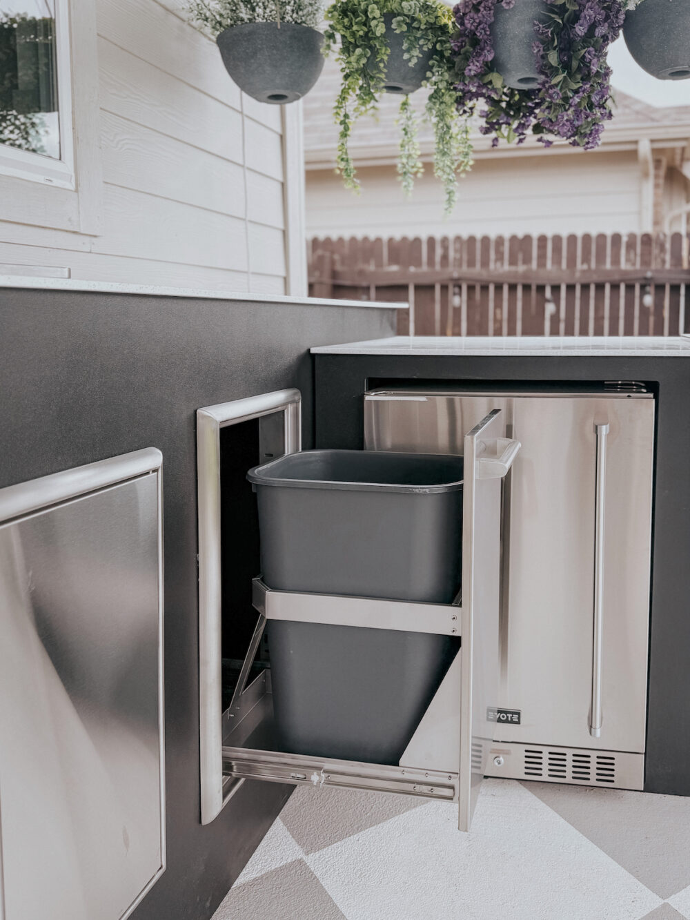 Open pull out trash can in outdoor kitchen