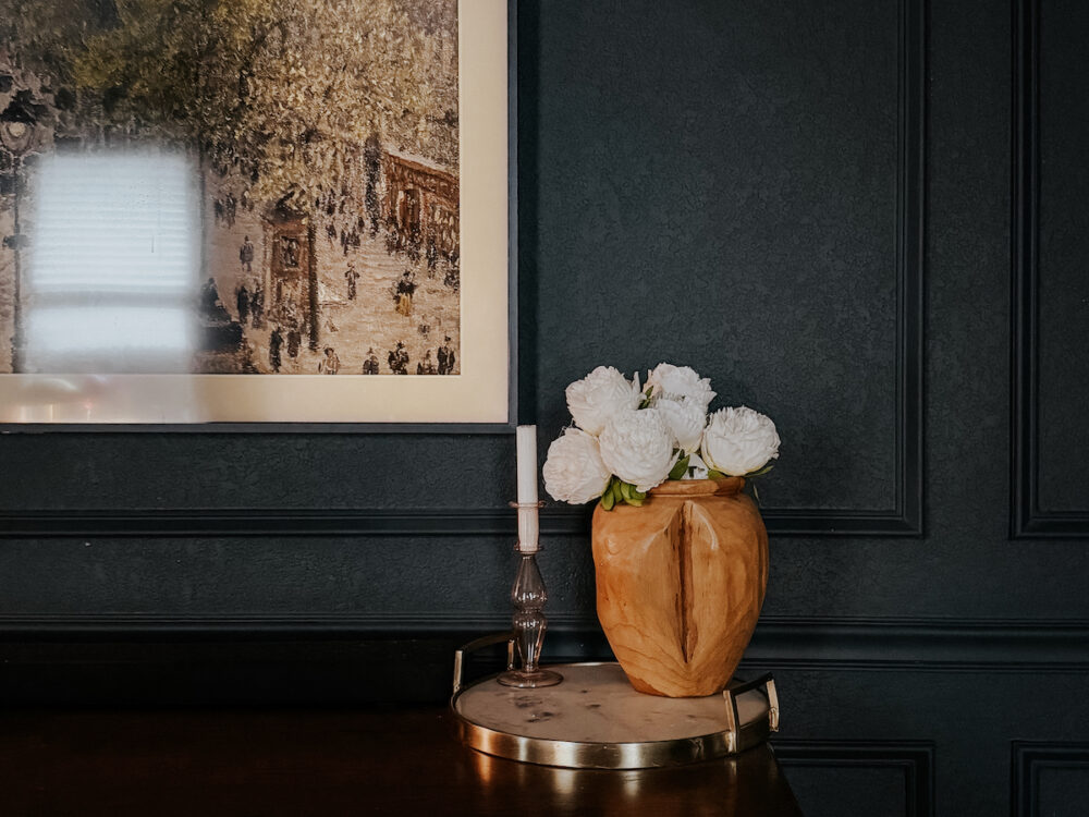 faux flowers in a vase on a dresser
