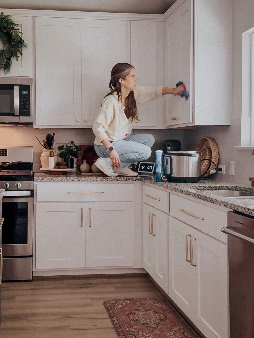 woman cleaning kitchen cabinets 