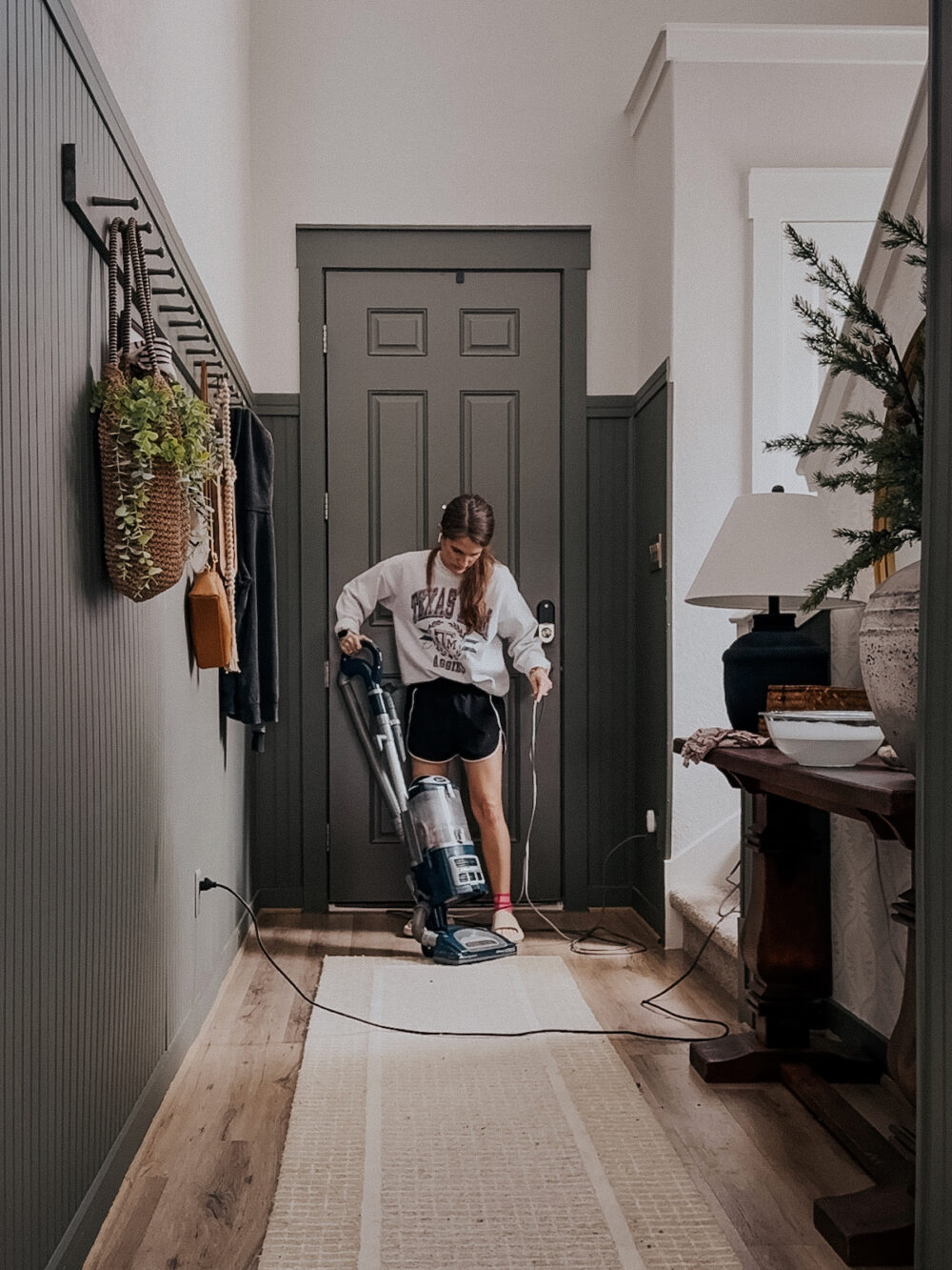 woman vacuuming the floor in an entry 