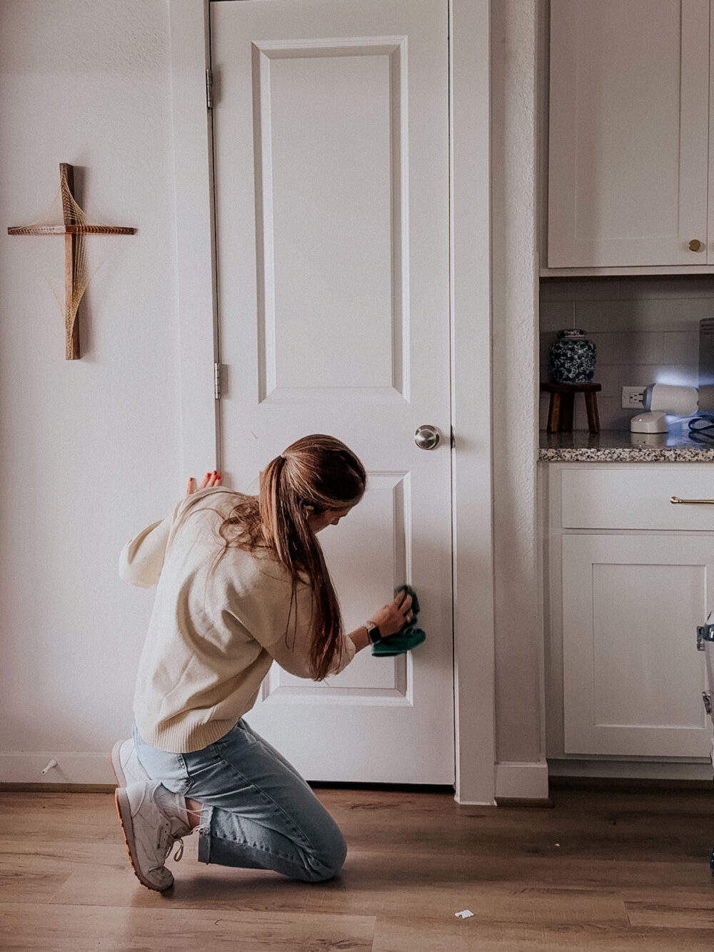 woman cleaning a door in a kitchen 