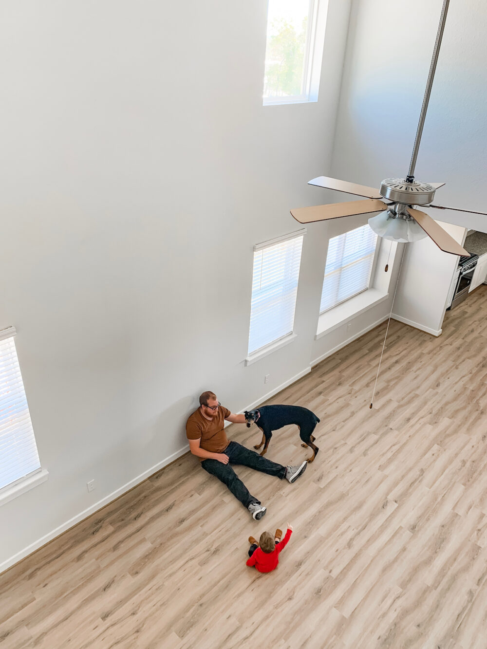 man and young boy sitting in an empty living room 