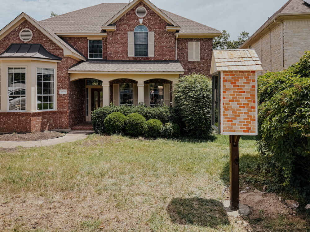 Red brick house with a free little library out front