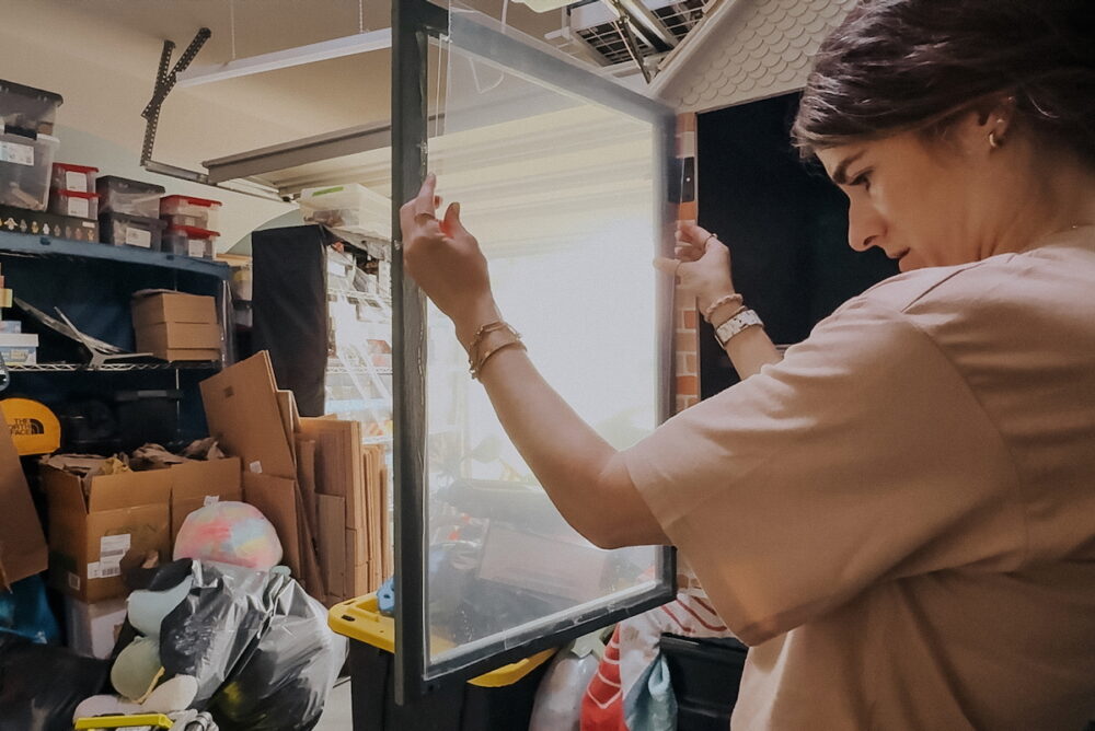 Woman adding plexiglass to a door for a puzzle library 
