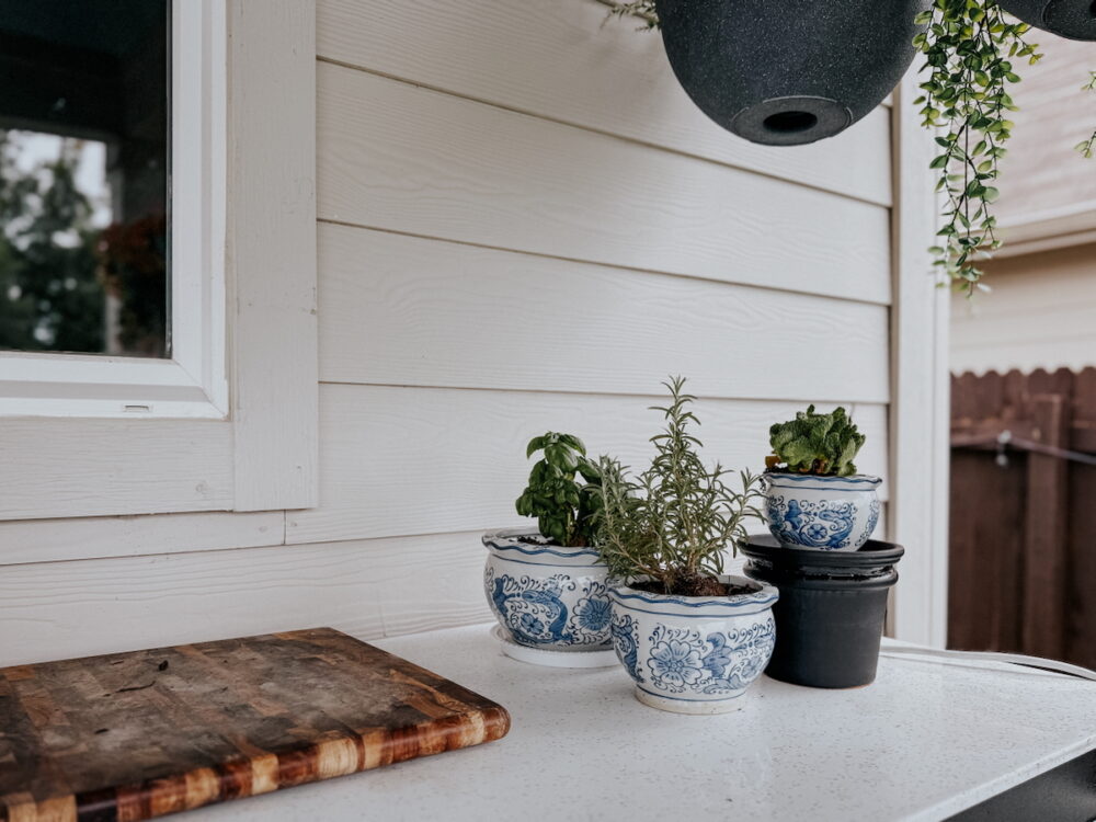 collection of planters, one of which is sitting on a simple DIY pedestal plant stand