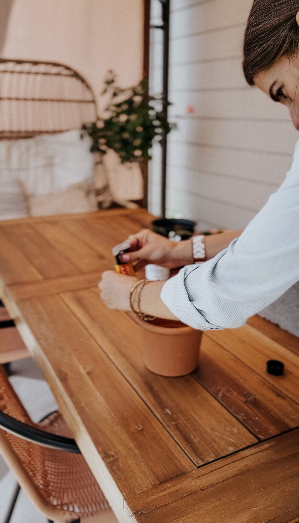 woman using a planter to create a DIY plant stand