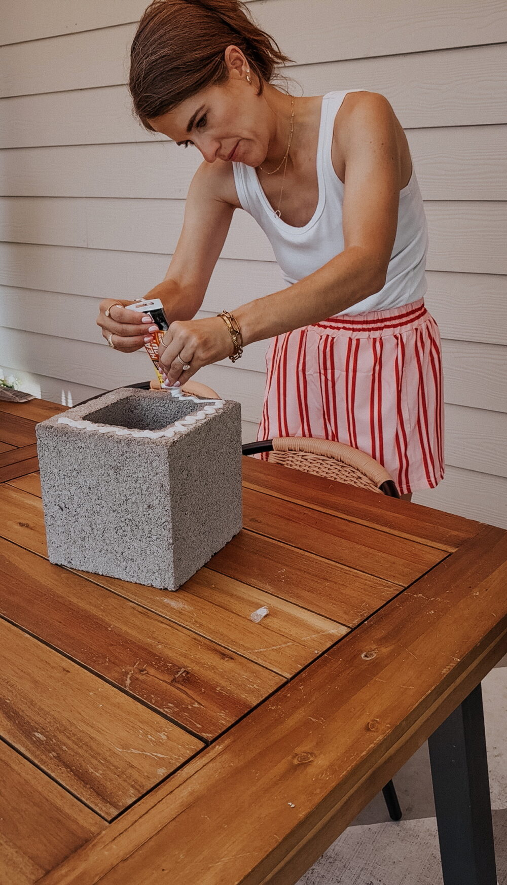 woman making a DIY plant stand with DAP construction adhesive