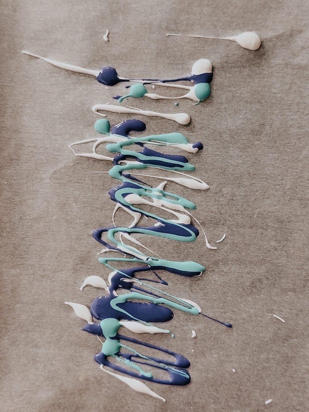 paint drizzled on parchment paper to create a DIY bookmark