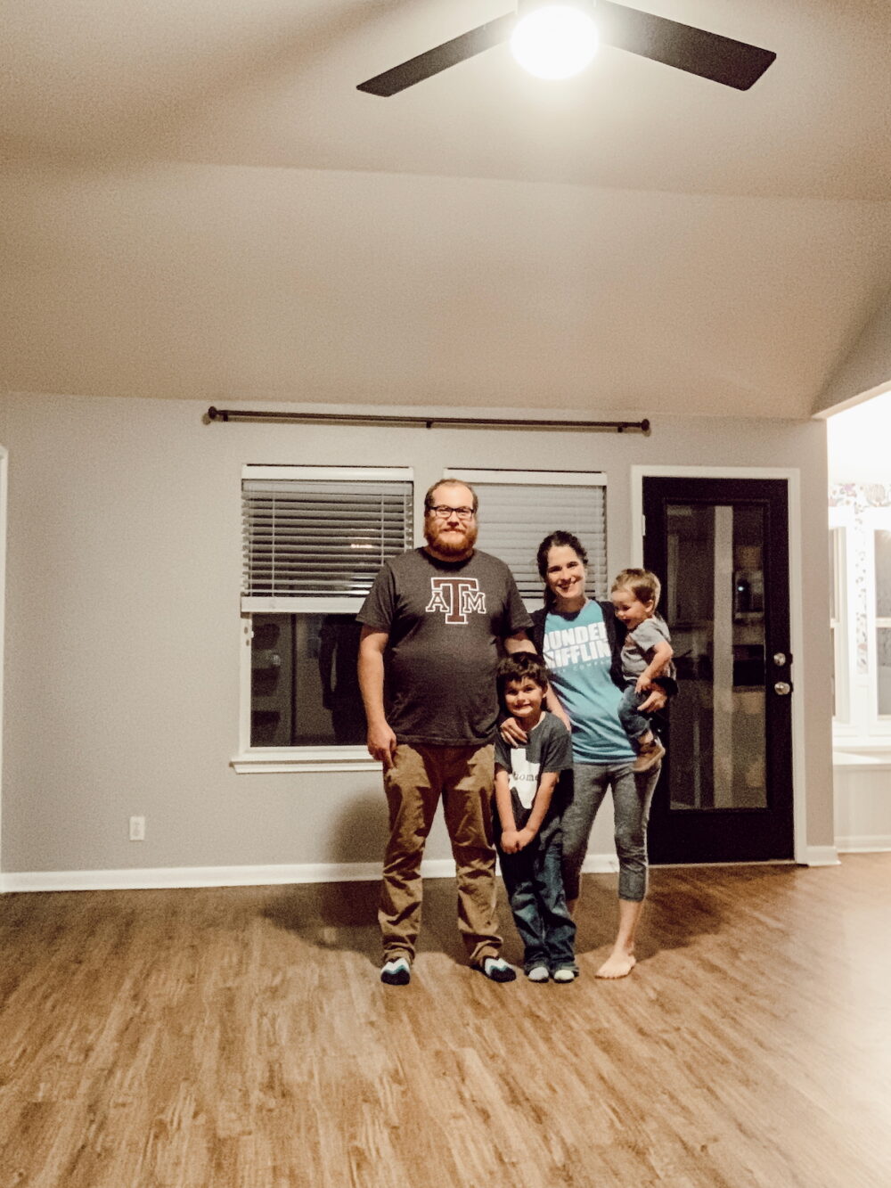family posing in an empty living room