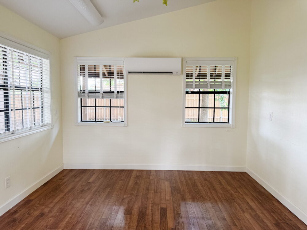 empty room with vaulted ceiling and large windows 