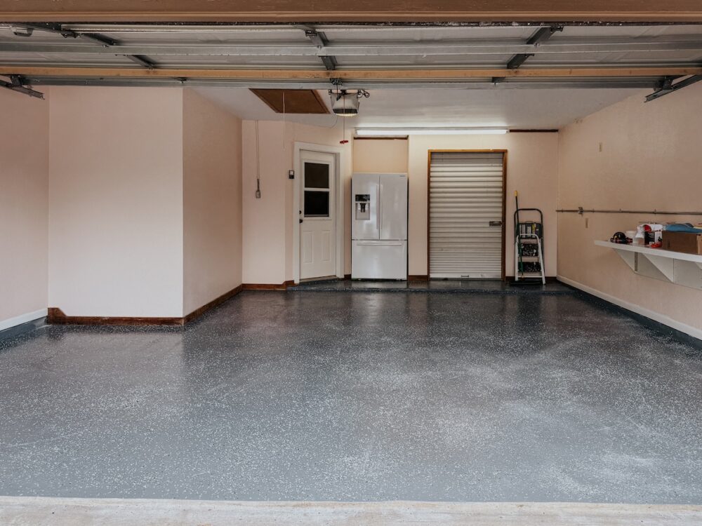 garage with epoxy garage floor and pink walls 
